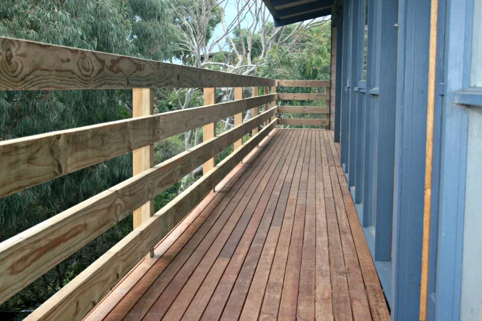 Elevated timber walkway deck with a timber handrail